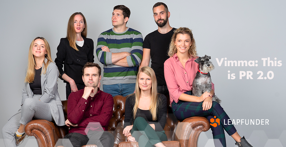 A group of people sitting on the sofa and posing for a photo